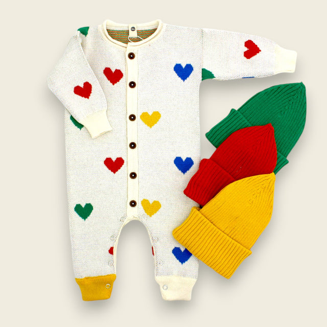 Knit Onesie with heart pattern and three winter hats, yellow, red, green. Shop Girls Collection.